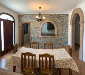 een eetkamer met een tafel en een stenen muur bij El Rincón de Caminito del Rey in Valle de Abdalagís