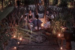 a group of people sitting on a porch with lights at Nomade Tulum in Tulum