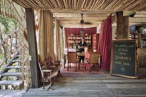 a woman sitting at a table in a library at Nomade Tulum in Tulum