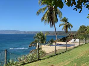 una playa con una valla, palmeras y el océano en Ocean View Echemare Tango Mar, en Tambor