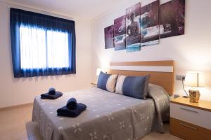 a bedroom with a bed with blue towels on it at Alicante Hills Luxury Beach Apartment in Alicante
