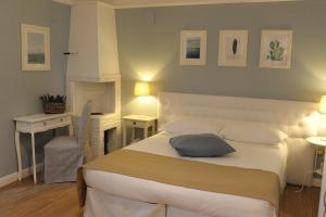 um quarto com uma grande cama branca e uma secretária em Aduepassi apartments em Manfredonia