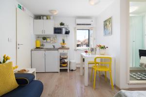 Cette chambre comprend une petite cuisine avec une table et des chaises jaunes. dans l'établissement Guest House Babina - Apartments King & Queen, à Split