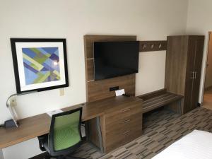 a large flat screen tv sitting on top of a wooden desk at Holiday Inn Express & Suites - Pittsburgh - Monroeville, an IHG Hotel in Monroeville