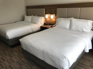 two beds in a hotel room with white sheets at Holiday Inn Express & Suites - Pittsburgh - Monroeville, an IHG Hotel in Monroeville