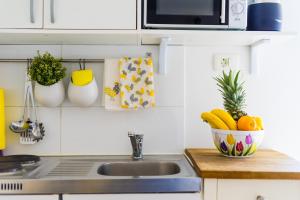 - un comptoir de cuisine avec un évier et un bol de fruits dans l'établissement Guest House Babina - Apartments King & Queen, à Split