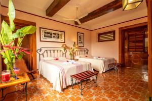 a room with two beds and a table at Hacienda Uxmal Plantation & Museum in Uxmal