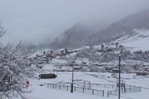 a village in the snow on a mountain at Apartment Jorjo Mestia in Mestia