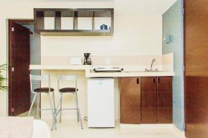 a kitchen with a sink and two bar stools at CondoHotel 5th Avenue Std Double Studio in Playa del Carmen +11 photos