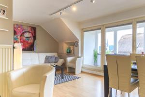 ein Wohnzimmer mit einem weißen Sofa und einem Tisch in der Unterkunft FeWo Seeperle mit Seesicht in Bodman-Ludwigshafen