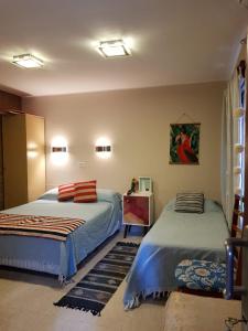 a bedroom with two beds and a painting on the wall at Taruca Apart in Salta