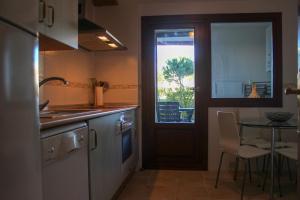 une cuisine avec une table et une porte avec une fenêtre dans l'établissement (PAR001) Modern Garden Apartment, à Ayamonte