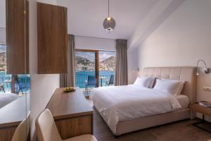 a bedroom with a bed and a view of the ocean at PALMA city HOTEL in Sarandë