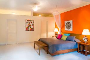 a bedroom with a bed with an orange wall at Hotel Montana in Petionville