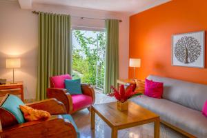 a living room with colorful furniture and a large window at Hotel Montana in Petionville