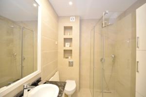 ein Bad mit einer Dusche, einem WC und einem Waschbecken in der Unterkunft Langust - free parking in Sveti Stefan