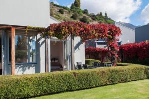 a house with a garden with red flowers at Sunrise Sanctuary in Wanaka
