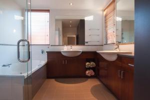a bathroom with two sinks and a tub and a mirror at Sunrise Sanctuary in Wanaka