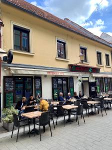 un grupo de personas sentadas en las mesas fuera de un restaurante en Patrick's Pub, en Maribor