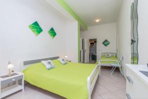1 dormitorio con cama verde y escritorio en Studio Apartments Romina, en Vrsar