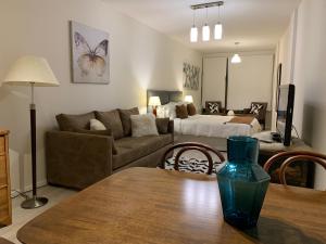 uma sala de estar com um sofá e uma cama em URBANA SUITES & STUDIOS 440 em San Carlos de Bariloche