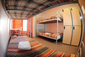 a room with two bunk beds and a kitchen at Be Zaragoza Hostel in Zaragoza