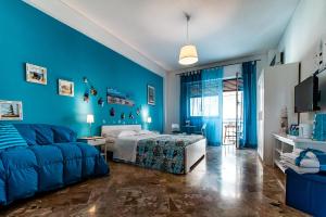 ein blaues Schlafzimmer mit einem Bett und einem Sofa in der Unterkunft Le stanze di Irma in Palermo