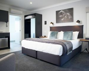 - une chambre avec un grand lit dans l'établissement Kelly Rd Cambridge Lodge, à Cambridge