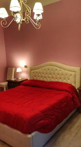 a bedroom with a bed with a red comforter at Casa Vacanza Katiuscia in Rome