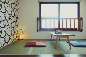 uma sala de estar com uma mesa e uma janela em Guesthouse Soi em Quioto
