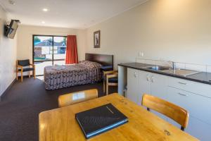 a kitchen and living room with a table and a bed at Cherylea Motel in Blenheim