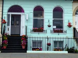 a blue house with flowers on the front of it at A MAIDEN REST in Weymouth