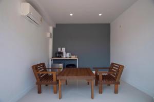 a dining room with a wooden table and two chairs at BHIVE in Nakhon Phanom