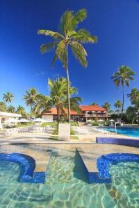 a swimming pool with palm trees in a resort at Hotel Village Porto de Galinhas - Apartamento 215 in Porto De Galinhas