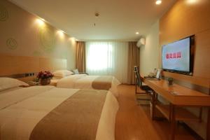 Una televisión o centro de entretenimiento en Greentree Inn Shanghai Hongqiao Airport Apartment Hotel
