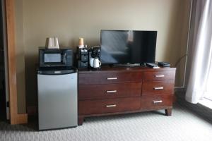 a tv sitting on top of a dresser next to a dresser with at Sitka Hotel in Sitka