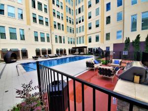 a balcony with a swimming pool in front of a building at Regal Stays Corporate Apartments - Downtown Dallas in Dallas