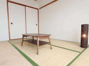 a wooden table sitting on a floor in a room at 湘南茅ヶ崎/湘南ライフの楽しめるアパートメント in Chigasaki