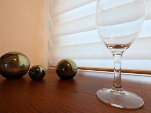 a wine glass sitting on top of a wooden table at 湘南茅ヶ崎/湘南ライフの楽しめるアパートメント in Chigasaki