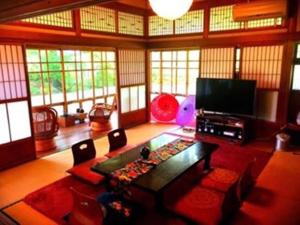 - un salon avec un canapé et une télévision dans l'établissement 里や, à Itoshima