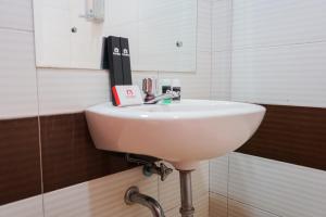 un lavabo blanc dans une salle de bain avec un miroir dans l'établissement Homey Studio Apartment at Margonda Residence 3 By Travelio, à Depok 5 autres photos