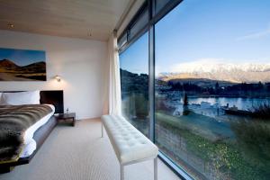 a bedroom with a large window with a view of the mountains at Forty Two by Amazing Accom in Queenstown