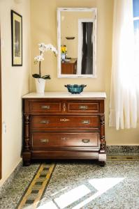 a dresser in a room with a mirror at Elena's Guest House in Aegina Town