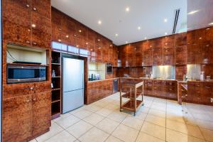 a large kitchen with wooden walls and a refrigerator at Exclusive Stays - Gallery Penthouse in Melbourne