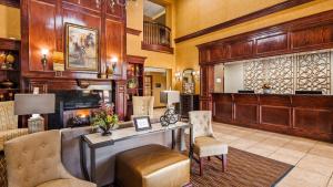 a lobby with a fireplace and a desk and chairs at Best Western Plus Crown Colony Inn & Suites in Lufkin