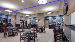 a restaurant with tables and chairs and a bar at Best Western Plus Lake Jackson Inn & Suites in Lake Jackson