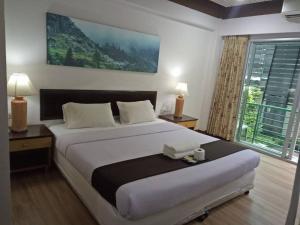 a bedroom with a large bed and a large window at Thai Inter Korat Hotel in Nakhon Ratchasima