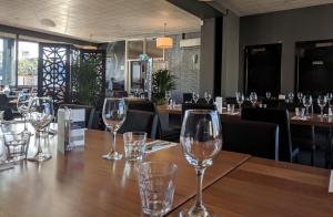 a table in a restaurant with wine glasses on it at Prince Of Wales Hotel in Hobart