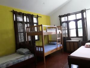 um quarto com 2 beliches e 2 janelas em Akogo House - Hostel and Backpackers em Mombaça
