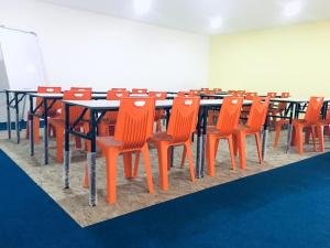 een conferentieruimte met tafels en oranje stoelen bij Place2Stay @ Kenyalang in Kuching